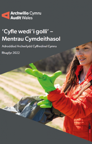 Dynes yn gwisgo menig rwber yn casglu sbwriel